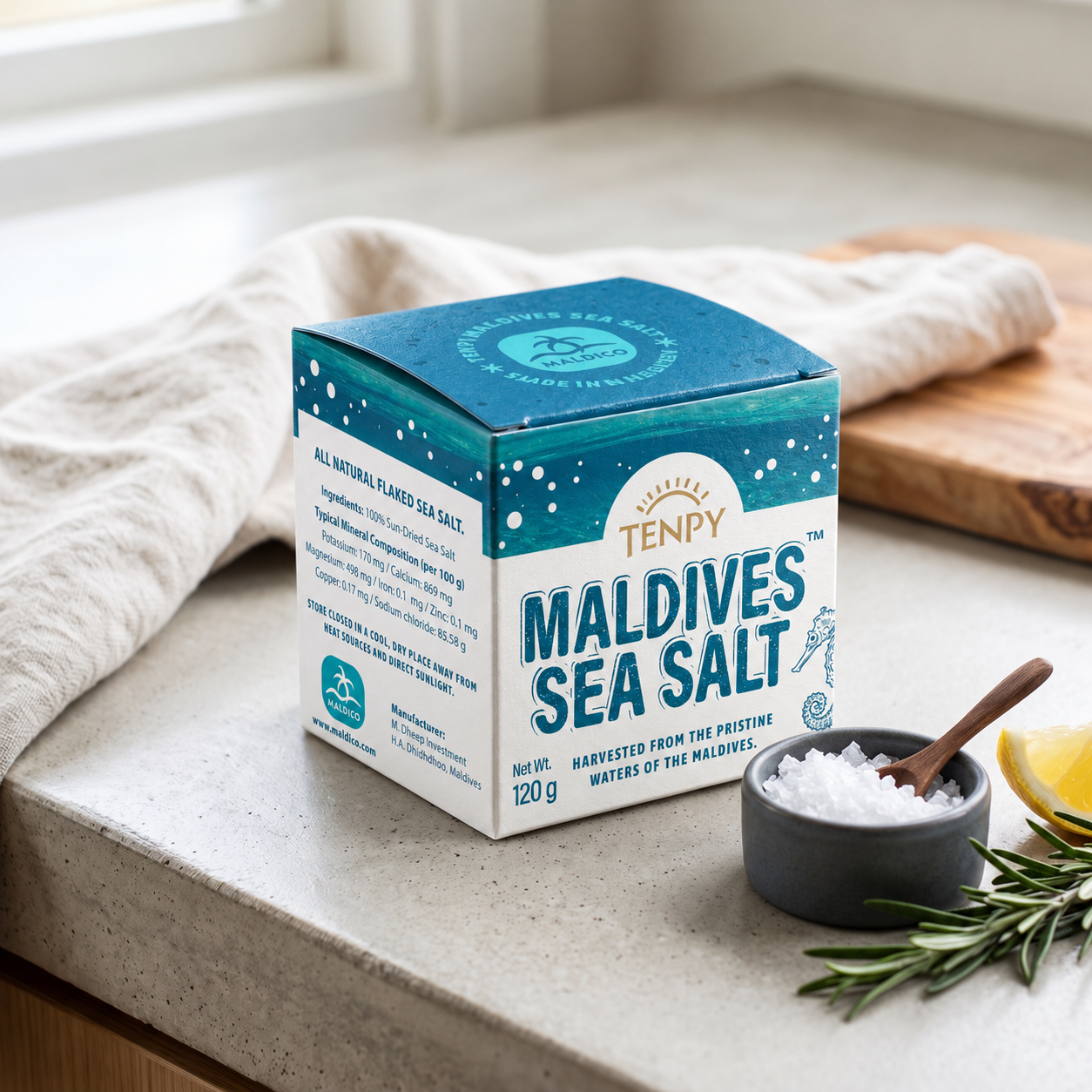 The Maldives Sea Salt box on a stone counter beside a bowl of salt