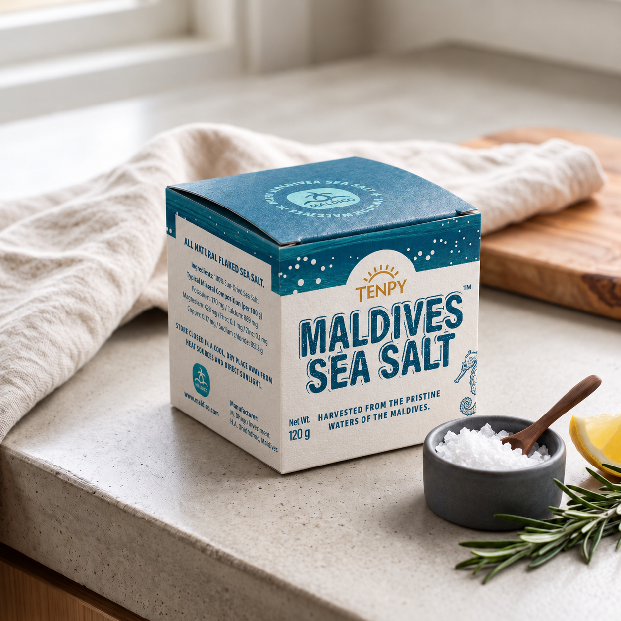 The Maldives Sea Salt box on a stone counter beside a bowl of salt